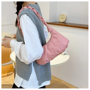 Detail showing pink pleated cloud bag with braided shoulder strap and soft matte finish