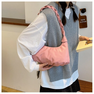 Detail view of pink cloud hobo bag featuring a wide woven shoulder strap and pleated design