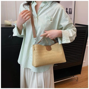 Détail du sac fourre-tout beige effet crocodile avec des lanières marron élégantes