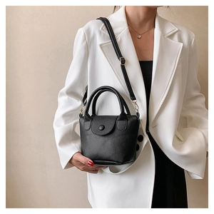 Détail du mini sac minimaliste en cuir noir avec poignées rondes et bandoulière