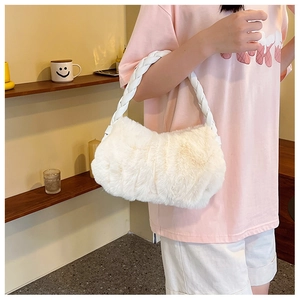 Détail du sac à bandoulière en fausse fourrure blanche avec anse tressée sur modèle