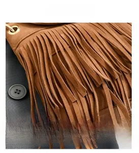 Détail du sac en daim marron montrant les franges multicouches et les œillets métalliques
