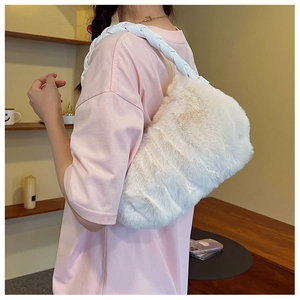 Détail d'un sac porté épaule en fausse fourrure blanche avec bandoulière tressée