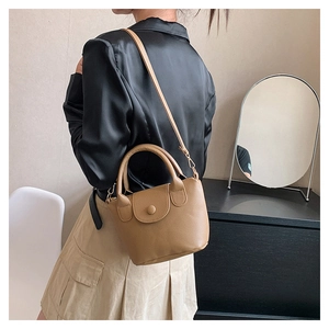 Détail d'un sac seau en cuir grainé kaki avec poignée ronde et bandoulière fine