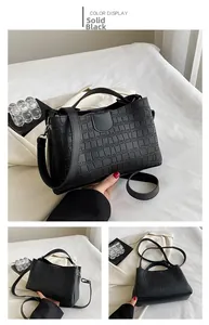 Détails d'un sac à main noir texture crocodile avec boucle métal et bandoulière cuir