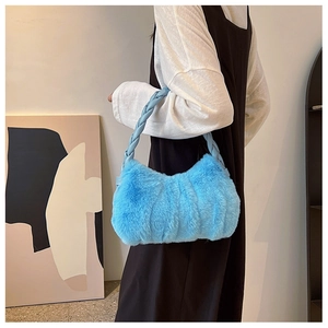 Détail du sac à main bleu clair en fausse fourrure avec anse tressée et texture nuageuse