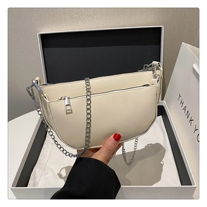 Chic creamy white half-moon underarm bag with silver chain strap in an elegant gift box
