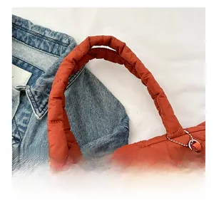 Detail of orange quilted padded handle with diamond stitching on large tote bag