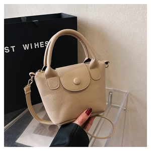 Vue détaillée du mini sac à main beige en cuir grainé avec poignée et bandoulière réglable