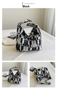 Detail of black and white knitted tote bag featuring rabbit patterns and knotted handles