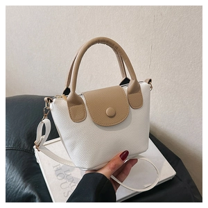 Vue détaillée d'un mini sac à main bicolore blanc et kaki avec texture cuir litchi