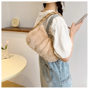 Gros plan d'un sac à bandoulière en fausse fourrure avec une anse tissée chic