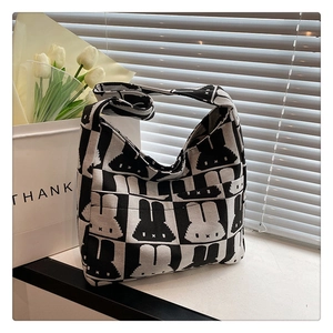 Detailed texture of checkered knit bag with cartoon rabbit pattern in sunlight