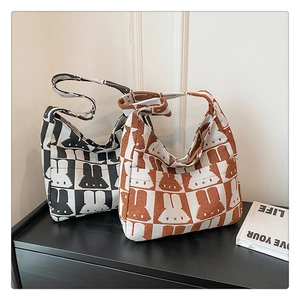 Detail of knitted tote bag showing checkerboard pattern and rabbit jacquard texture