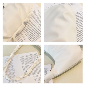 Close-up detail of cream white pleated cloud bag with unique woven handle textures