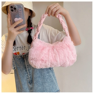 Détail du sac à main rose en fausse fourrure avec poignée en cuir tressé et texture douce