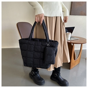 Detail view of the black quilted puffer tote bag with a matching small coin purse accessory