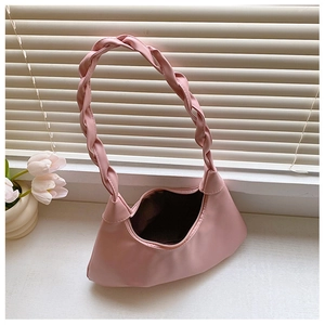 Detail of light pink pleated cloud bag with a chunky braided handle and zipper closure