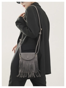 Détail d'un sac bandoulière en daim gris avec de longues franges sur un mannequin