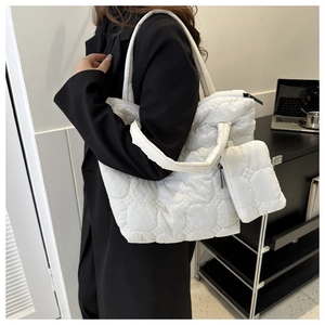 Detail view of white quilted puffer tote bag with matching small hanging pouch