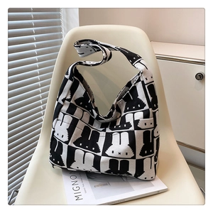 Detailed knit texture of Miffy style checkerboard tote bag on a modern white chair