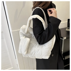 Detail of white quilted puffer tote bag with small matching purse on black blazer