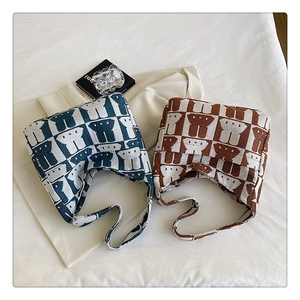 Detail shot of blue and brown checkered knit tote bags with abstract rabbit patterns
