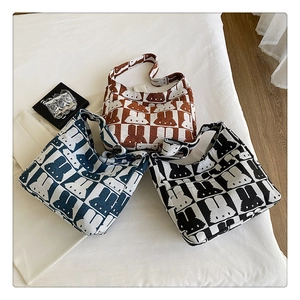 Three knitted rabbit pattern tote bags in caramel, denim blue, and black colors