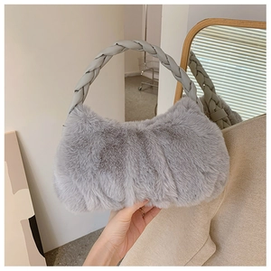 Détail d'un sac à main en fausse fourrure gris clair avec une poignée tressée douce