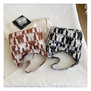 Detail of checkered knit hobo bags in caramel and black with cartoon patterns