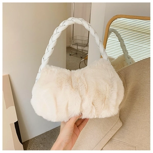 Détail de la texture en fausse fourrure blanc crème et de l'anse en cuir tressé du sac à main