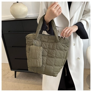 Detail of olive green quilted tote bag with matching coin purse on a metal chain