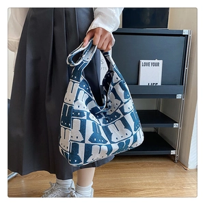 Lifestyle view of the thick knit shoulder bag with blue and white cartoon rabbit patterns