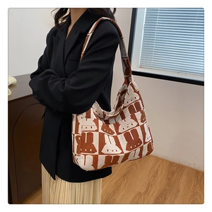 Brown and white knit shoulder bag with cute rabbit pattern carried by a model