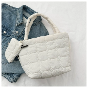 Detail of white quilted puffer tote bag with matching small coin purse and soft fabric texture