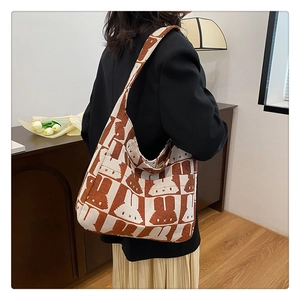 Detailed knit hobo bag with rabbit print and checkered brown patterns shown on model
