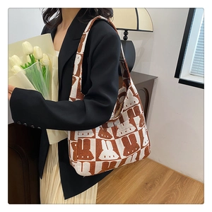 Close-up of the checkerboard knit pattern and rabbit design on this brown shoulder bag