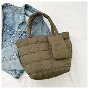 Detailed macro view of olive green quilted puffer bag with matching zipper pouch