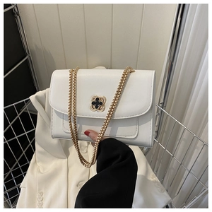 Détail du sac à chaîne en cuir blanc avec fermoir en fleur et bandoulière en métal doré