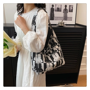 Close-up of a large capacity tote bag featuring pixelated rabbit patterns and wide straps