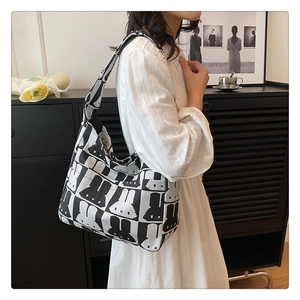 Close-up of the knitted shoulder bag with artistic black and white rabbit pattern detail