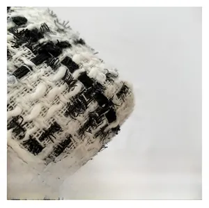 Detailed macro view of black and white tweed fabric with classic woven texture finish