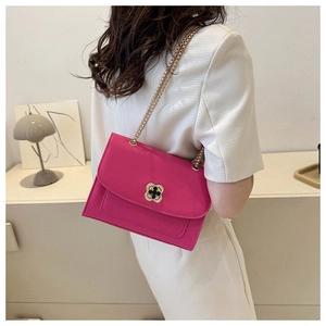 Détail du sac bandoulière fuchsia en cuir avec fermoir trèfle doré et chaîne