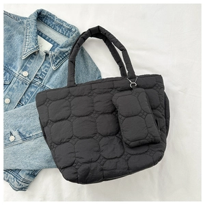 Close-up of black quilted puffer tote bag with matching mini pouch and chain detail