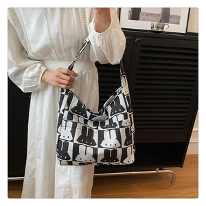 Close-up of hobo shoulder bag with trendy black and white rabbit prints and wide strap