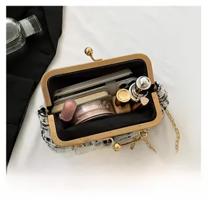 Detail view of tweed chain bag interior showing space for phone, lipstick, and perfume