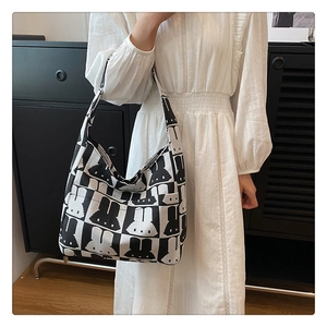 Close-up of a large capacity knitted tote bag featuring a black and white pixel rabbit design