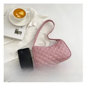 Pink quilted shoulder bag with classic diamond stitch pattern and integrated strap