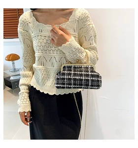 Detail of black and white houndstooth tweed bag with gold metal frame and ball lock clasp