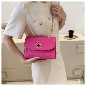 Détail du sac à bandoulière rose rouge avec fermoir fleur en métal et chaîne dorée